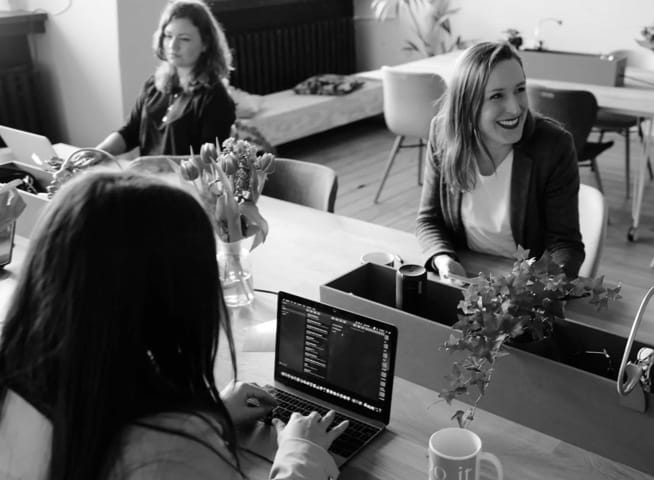 an abstract photo of women, working on their laptops